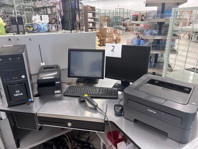 un bureau sur lequel se trouvent un ordinateur et une imprimante, dans un magasin