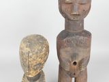 two small wooden figurines sitting next to each other on a white surface