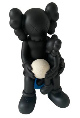 black kawshi figurine holding a white ball in his hands