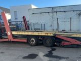 une photo d'une remorque à plateau garée sur un parking