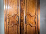 a large wooden cabinet with two doors on top of it