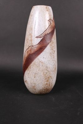 un vase blanc orné d'une plume marron