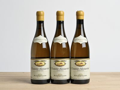three bottles of wine sitting on top of a wooden table