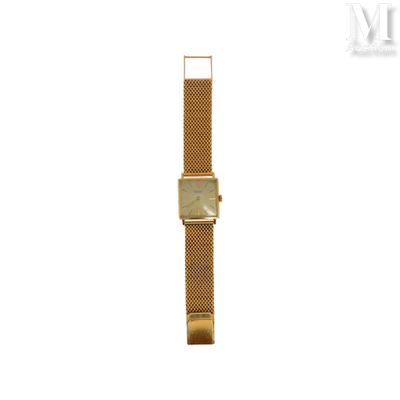 un gros plan d'une montre sur une surface blanche avec un fond blanc
