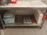 une cuisine équipée d'un évier et d'un plan de travail sur lequel sont posés des muffins