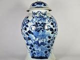 un vase bleu et blanc avec un couvercle posé sur une table