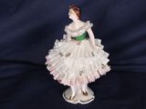 figurine en porcelaine représentant une femme vêtue d'une robe blanche et d'une ceinture verte
