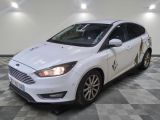 La Ford Focus blanche est garée dans une pièce dont le sol est à carreaux.