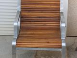 a metal and wood chair sitting outside of a building