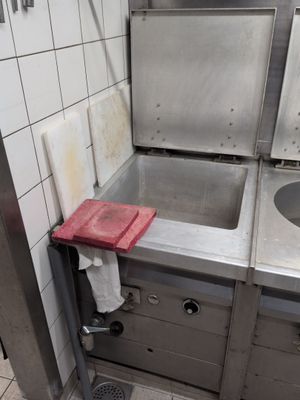 a sink in a kitchen with a red towel on the counter