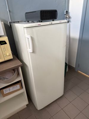 un réfrigérateur blanc et un micro-ondes dans une petite pièce