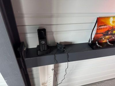 une photo montrant un téléphone portable et un DVD posés sur une étagère