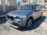 La BMW X1 est garée sur le bord de la route, dans un parking.