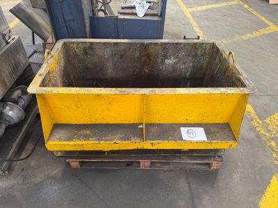 a yellow dumpster sitting in the middle of a parking lot