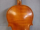 an antique violin with a wooden back and bow on display