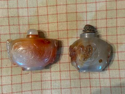 deux flacons en verre posés sur une table recouverte d'une nappe à carreaux