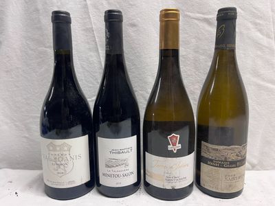 quatre bouteilles de vin sont alignées sur une table