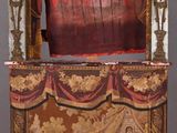 a small wooden box with a red curtain on top of it