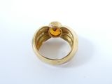 an image of a gold ring with a yellow stone in the middle