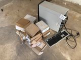 a computer sitting on a pile of boxes next to a keyboard