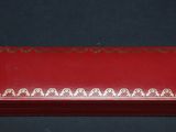 a red box with a gold design on it sitting on a black surface