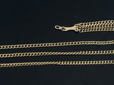 a close up of two gold chains on a black surface