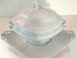 a white bowl with a lid on a saucer on a plate