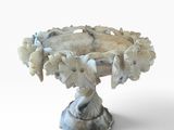 un socle blanc sur lequel est posé un bouquet de fleurs