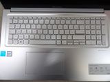 a silver laptop with a blue sticker on the keyboard