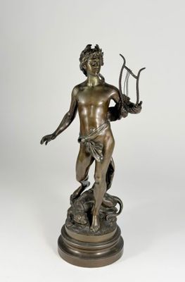 an antique bronze statue of a man holding a pitchfork