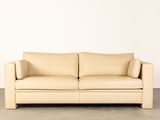 a picture of a tan leather couch against a white wall