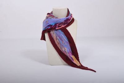 purple and red scarf on a mannequin stand on a white surface