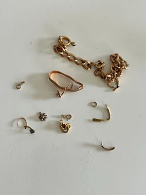 a lot of gold jewelry on a white surface
