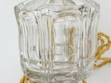 a glass bottle with a gold handle on a white surface