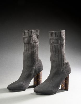 deux paires de chaussettes grises avec un talon en bois posées sur une surface blanche