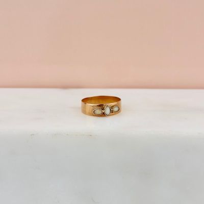gros plan d'une bague en or ornée de deux diamants