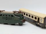 two toy trains sitting next to each other on a white surface