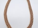 une image représentant un collier à chaîne en or sur fond blanc