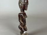 a small wooden figurine of a man with a hat on his head