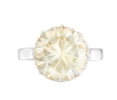 une bague en or blanc sertie d'un diamant de taille ovale entouré de diamants