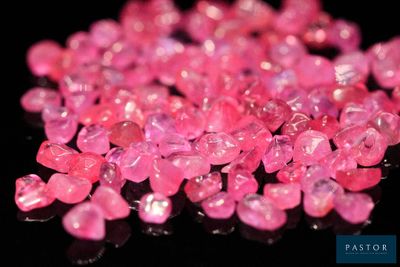 quelques diamants roses sont parsemés sur une surface noire