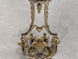 a wall sconce on the floor with a flower on it