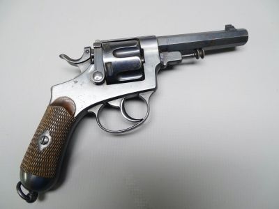 un vieux revolver avec une poignée en bois sur une surface blanche