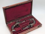 an old wooden case with two pistols inside of it