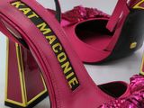 pair of hot pink high heeled shoes with a bow on the heel