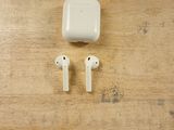 a pair of airpods sitting on a wooden table