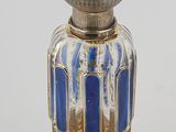 an image of a silver and blue glass perfume bottle on a white surface