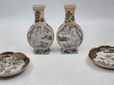trois vases et une assiette sont posés sur une surface blanche