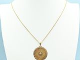 a gold necklace with a medallion pendant on a mannequin