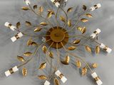 un gros plan d'un lustre doré et blanc accroché au mur